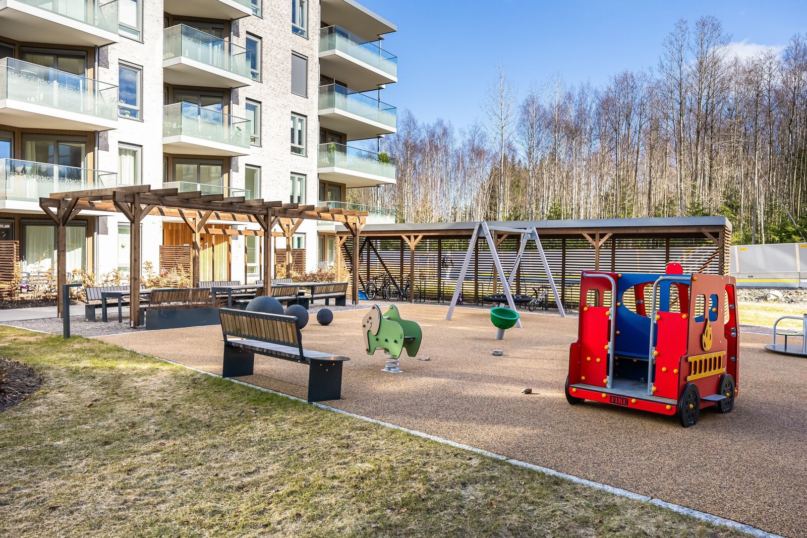 Den andre siden av uteområdet byr på lekeplass, sykkelstativer og sosiale soner Galleribilde