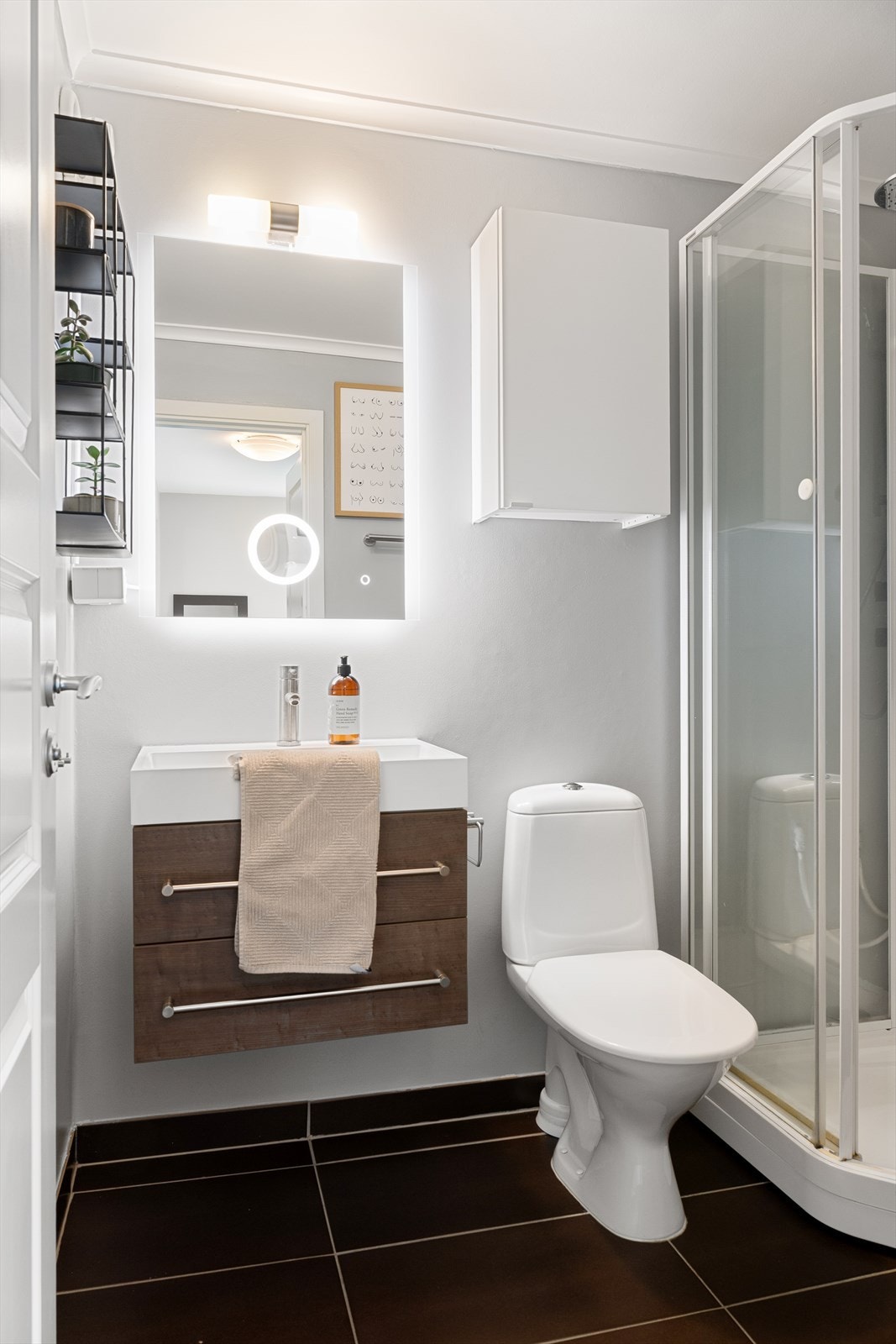 Badet i 1. etasje har fliser på gulv og er innredet med vask i seksjon, dusjkabinett og toalett. Galleribilde