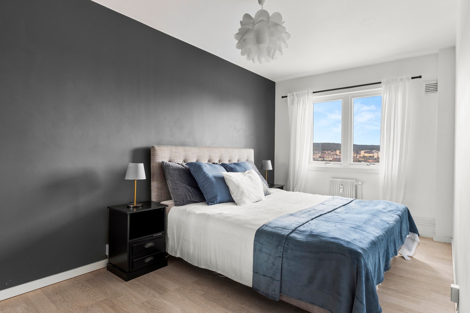 Romslig og harmonisk soverom med mørk kontrastvegg og god plass til dobbeltseng og nattbord. Galleribilde