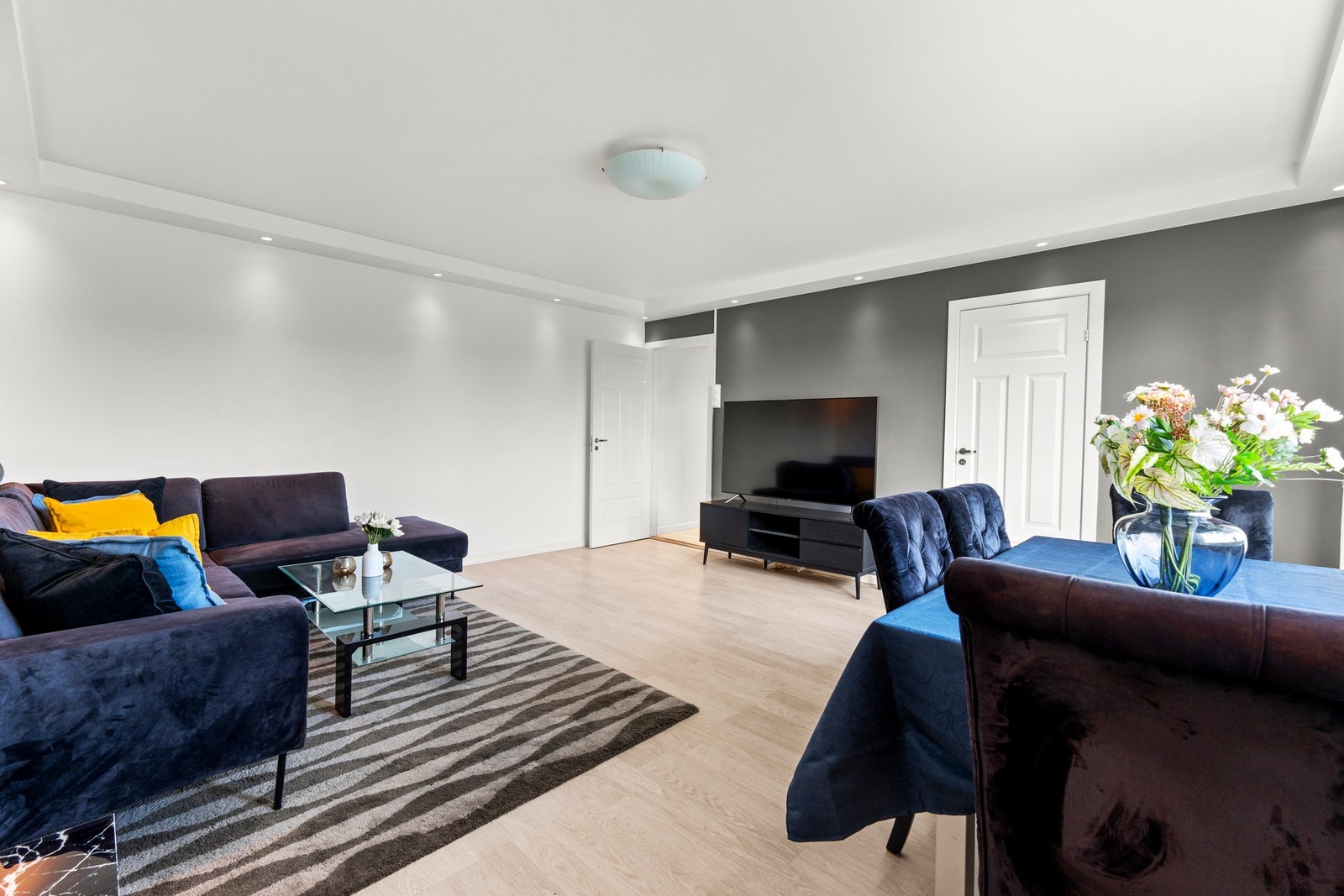 Åpen og innbydende stue med moderne fargevalg, fine møbleringsmuligheter og naturlig sonedeling mellom spise- og oppholdsdel. Galleribilde
