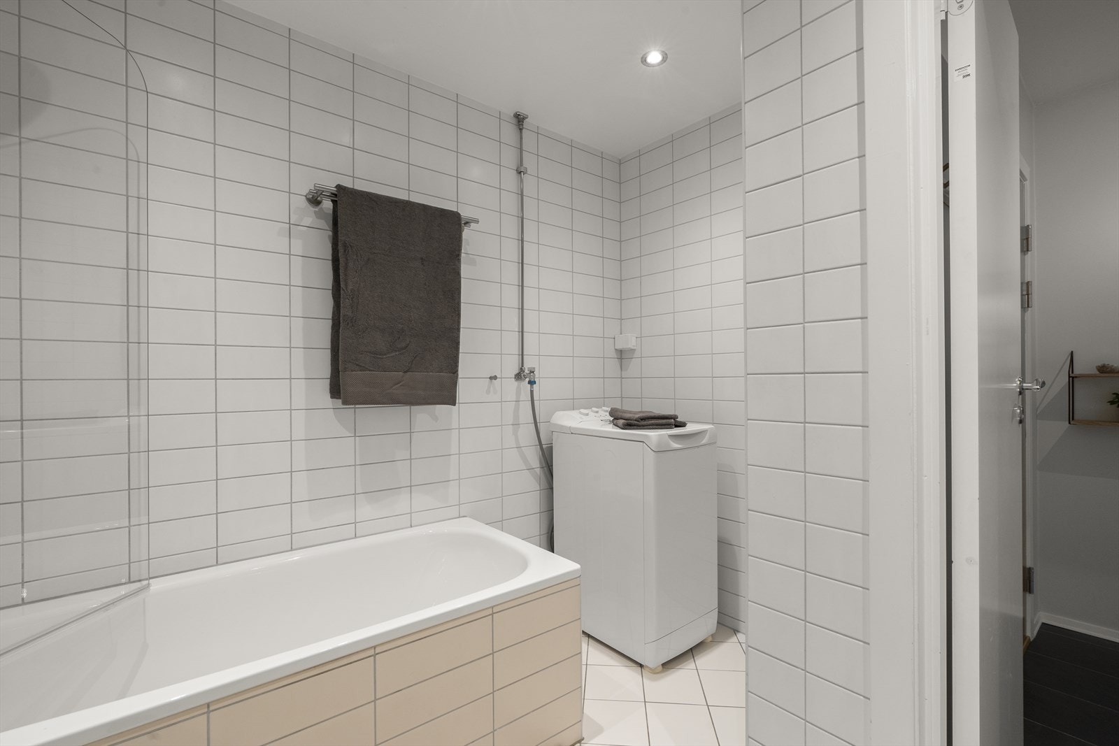 Badet er innredet med vegghengt klosett, servant nedfelt i innredning og speil med belysning, samt badekar med glassdører. Galleribilde