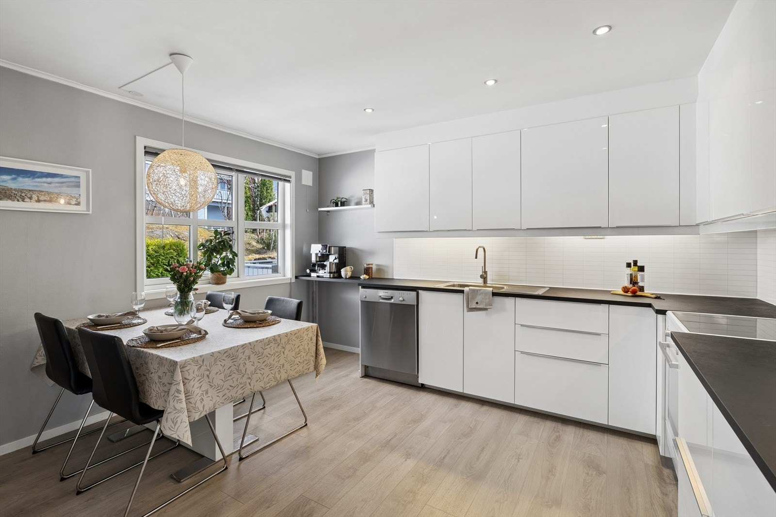 Kjøkkenet i har innredning fra IKEA med hvite glatte fronter i høyglans, benkeplater i laminat, rustfri oppvaskkum med avrenningsplate. Galleribilde