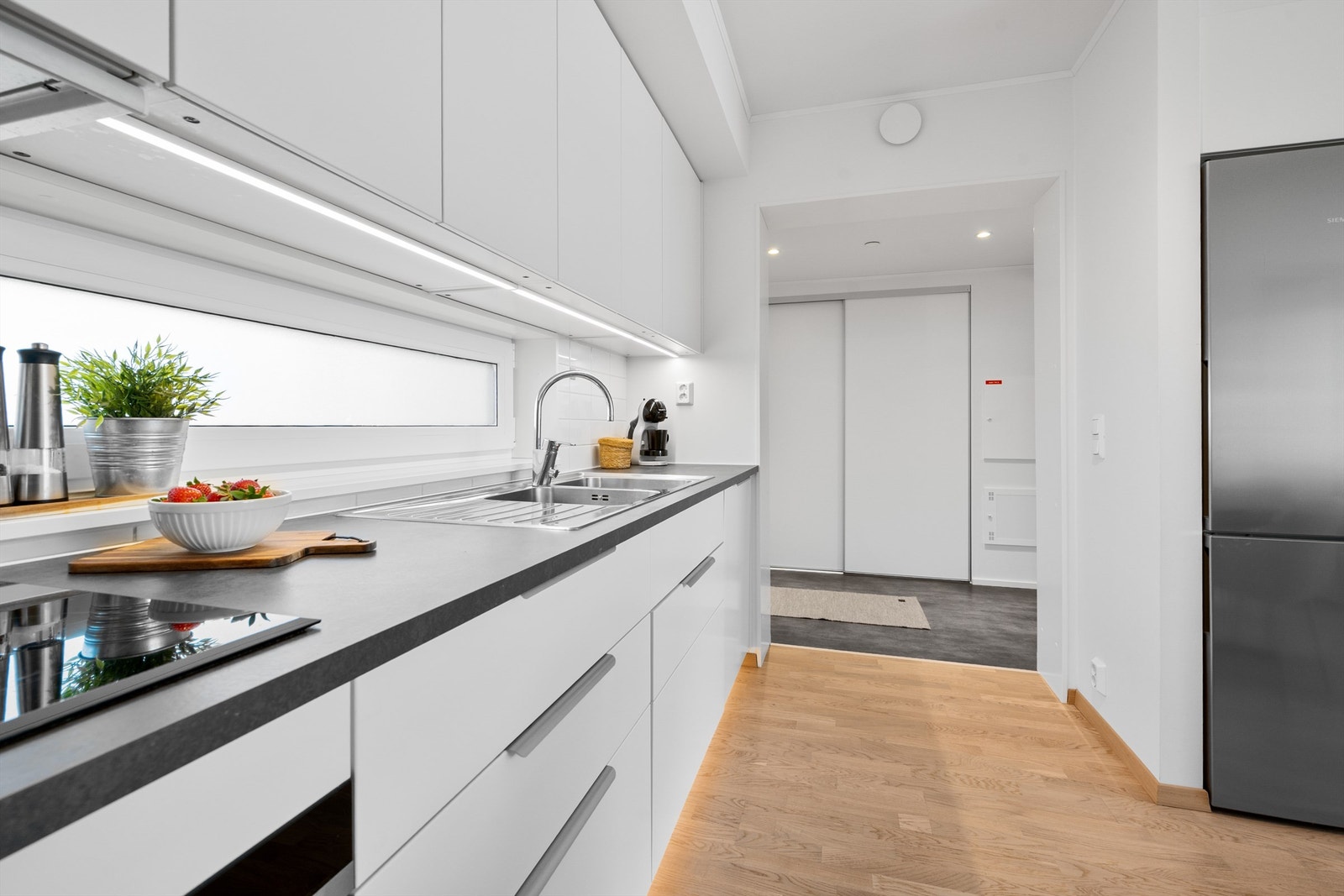 Kjøkkeninnredning fra byggeår med stilrene, slette fronter og praktisk laminat benkeplate. Galleribilde