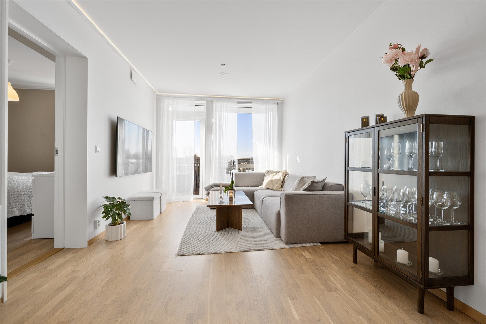 Lys stue med mye naturlig lys fra store vindusflater. Galleribilde