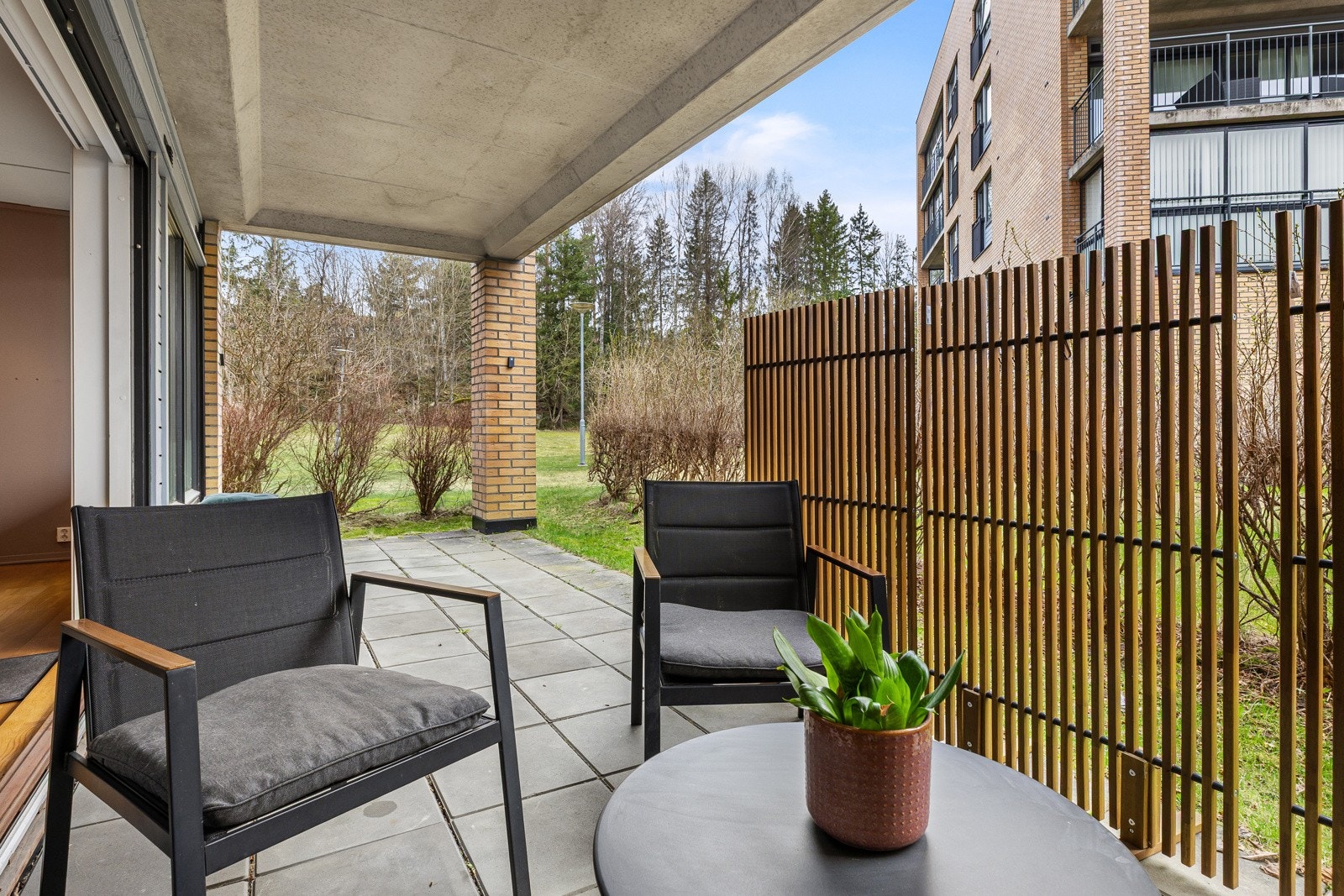Skjermet uteplass med fine soner for både spisegruppe og lounge Galleribilde