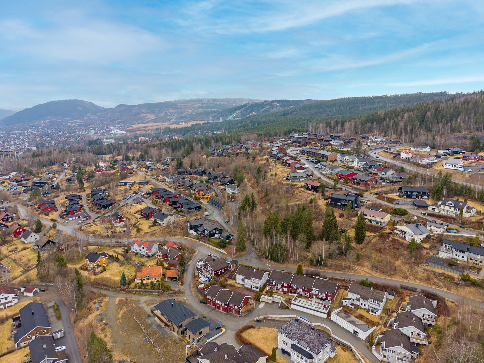 Luftfoto som viser boligfeltet med nærhet til fasiliteter, grøntområder og bebyggelse. Flott tursti sommer som vinterstid, rett i bakkant av boligen. Galleribilde