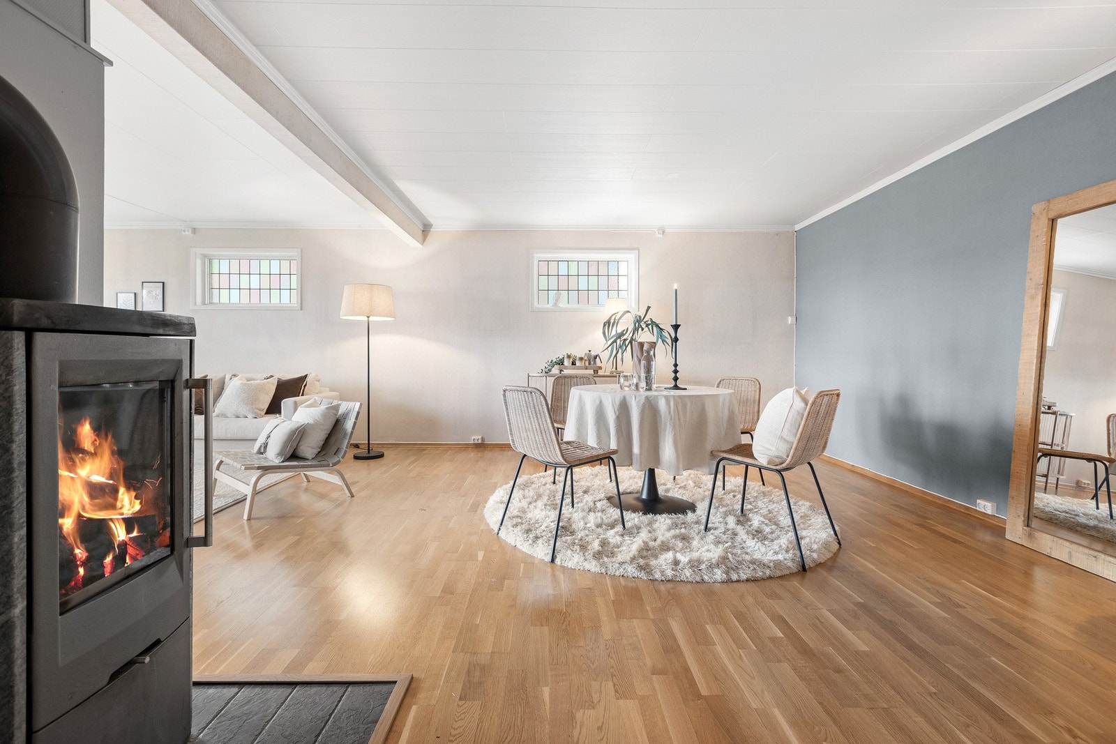 Stor og luftig stue med vedovn, god plass til både spise- og sittegruppe, og gjennomgående parkettgulv. Galleribilde