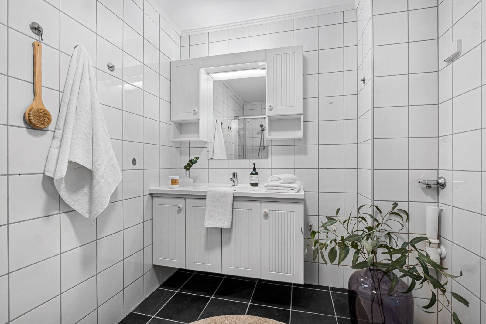 Tidløs innredning av servant, dusj innbygget med glasfiberstein, toalett og samt opplegg til vaskemaskin. Galleribilde