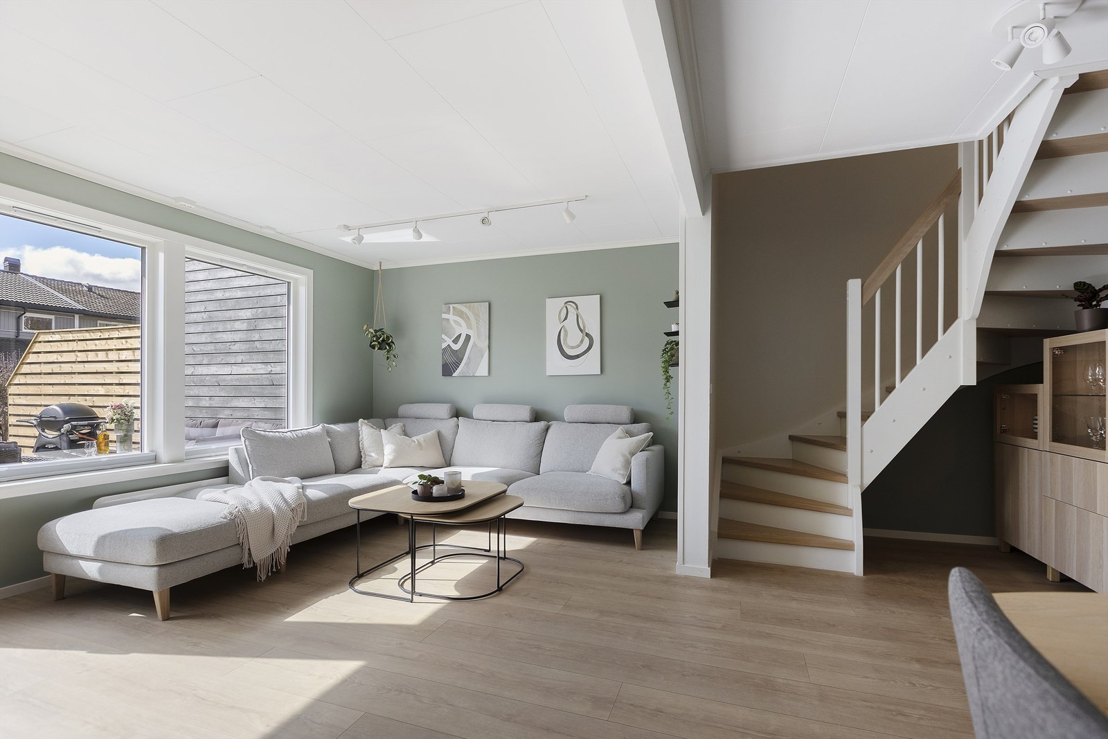 Stuen er et lyst og åpent rom med malte veggflater og plass til en romslig sofagruppe. Galleribilde