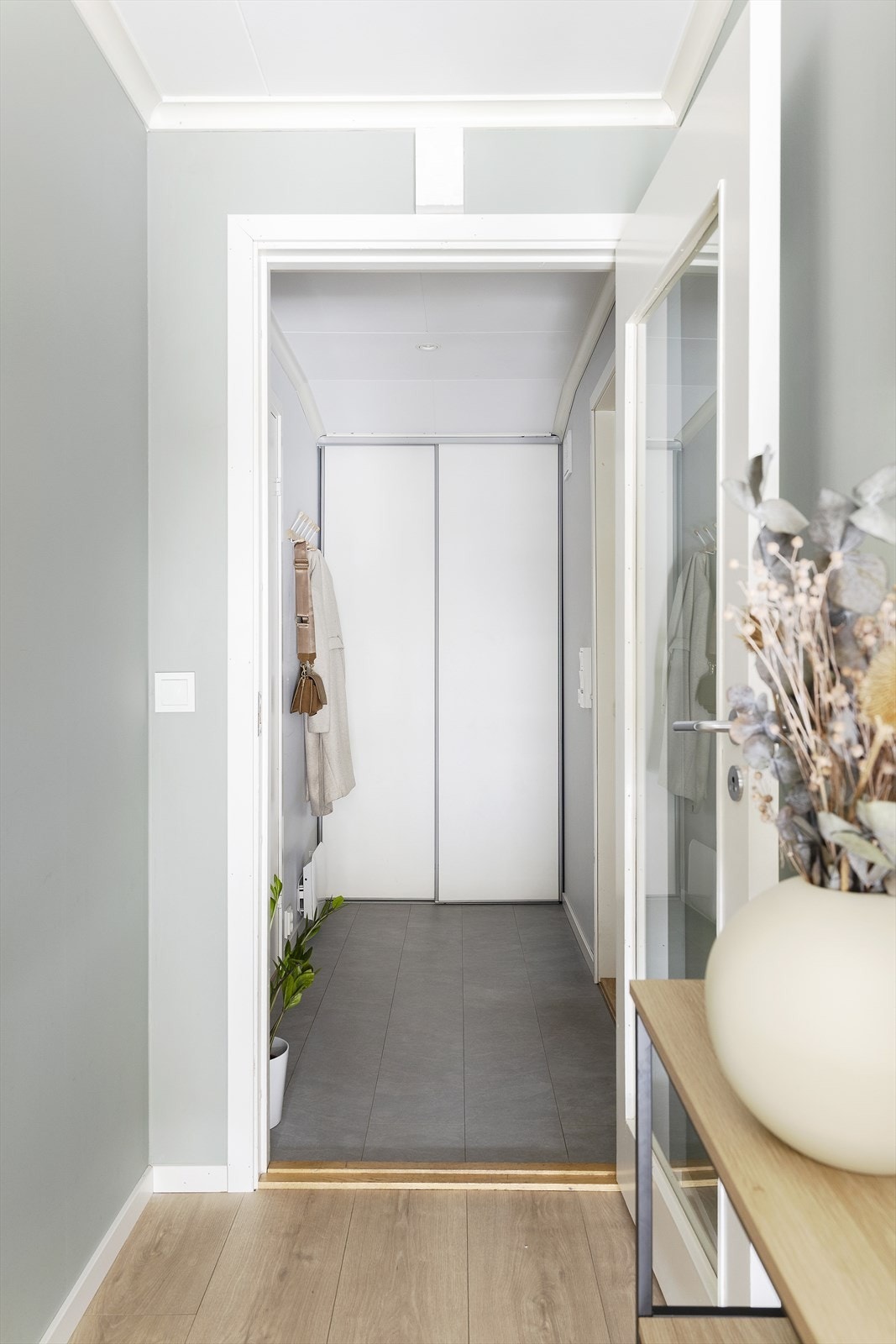 Man kommer inn i en entré med gulvvarme, skyvedørsgarderobe og knaggrekke. Galleribilde