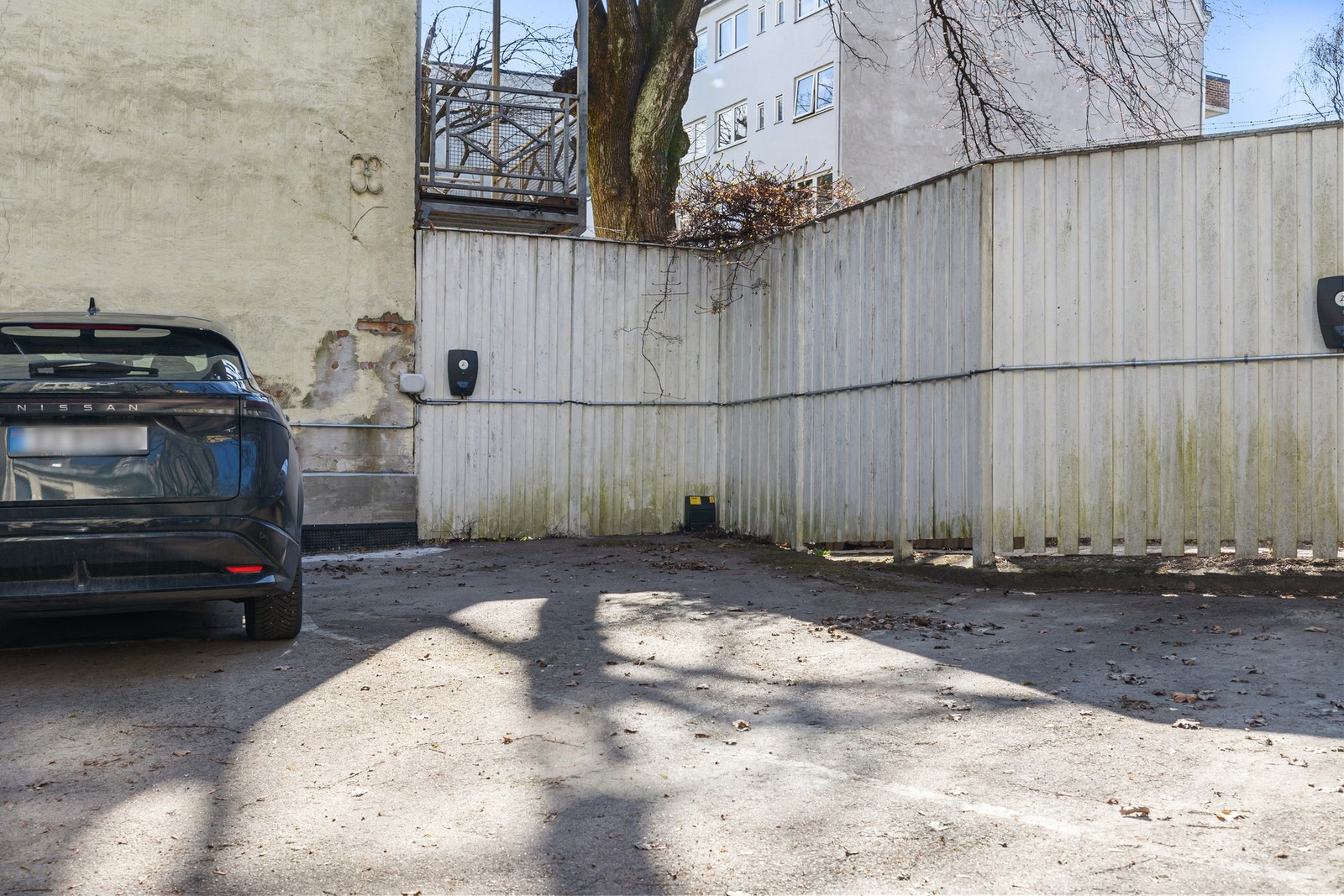 Parkeringsplass med lader for el-bil i bakgården. Galleribilde