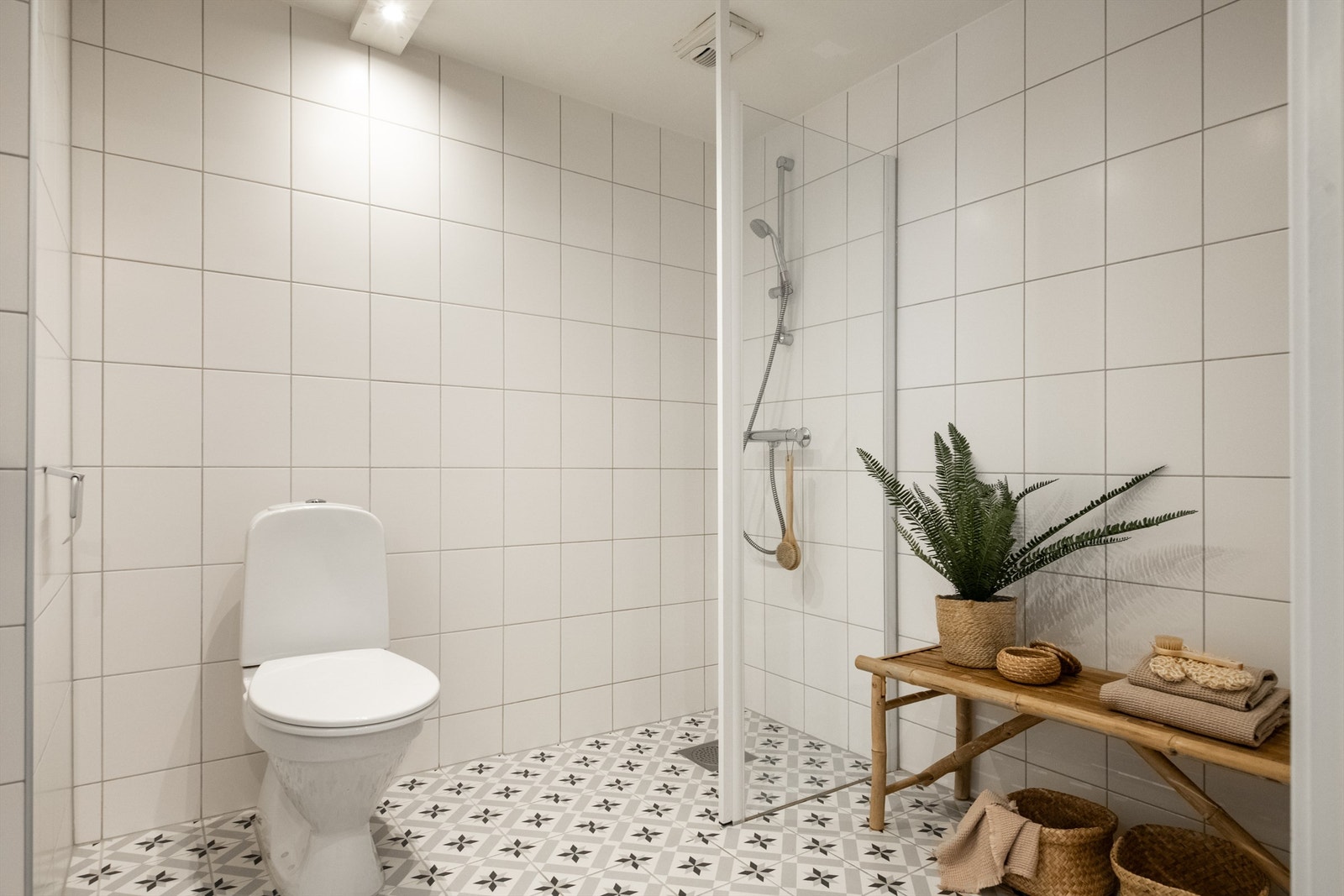 Tidløst flislagt bad av god størrelse. Her har man og plass til oppbevaring eller ønsket møblement til høyre for dusjhjørnet. Galleribilde