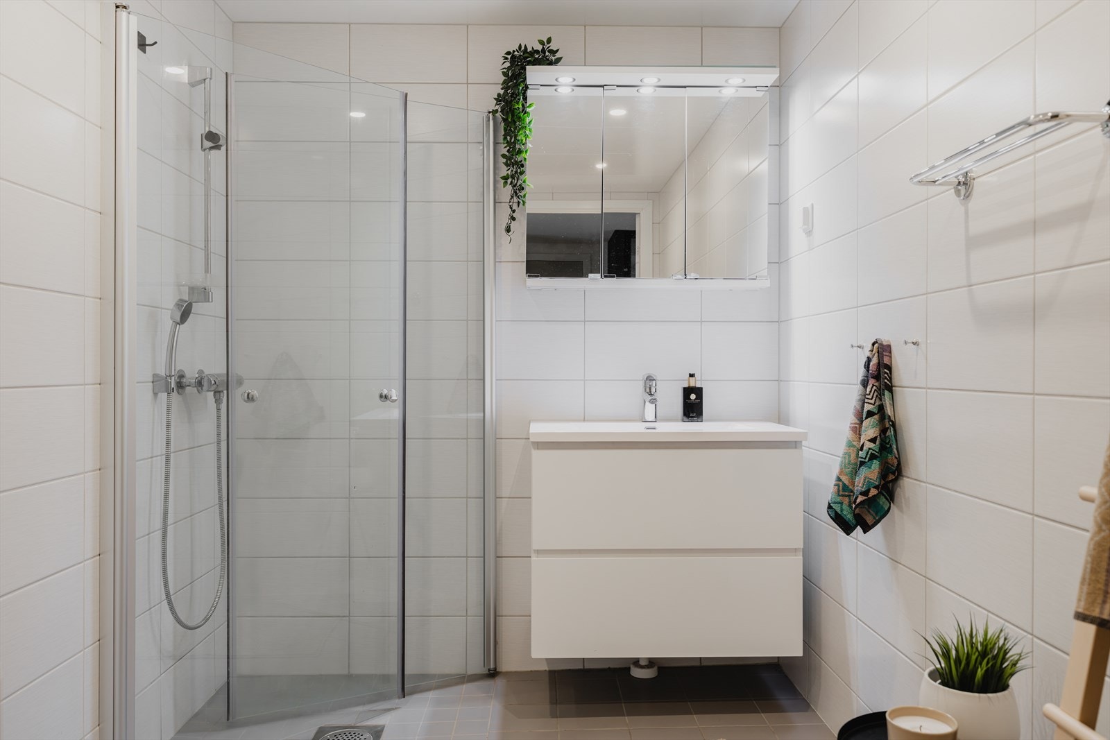 Badet har servant med skuffeseksjon og overskap med speilfronter og belysning. Galleribilde