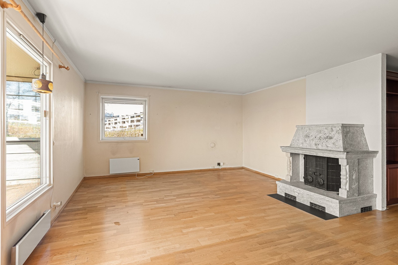 Stuen har vindu på gavlveggen og peis med innsats. Galleribilde