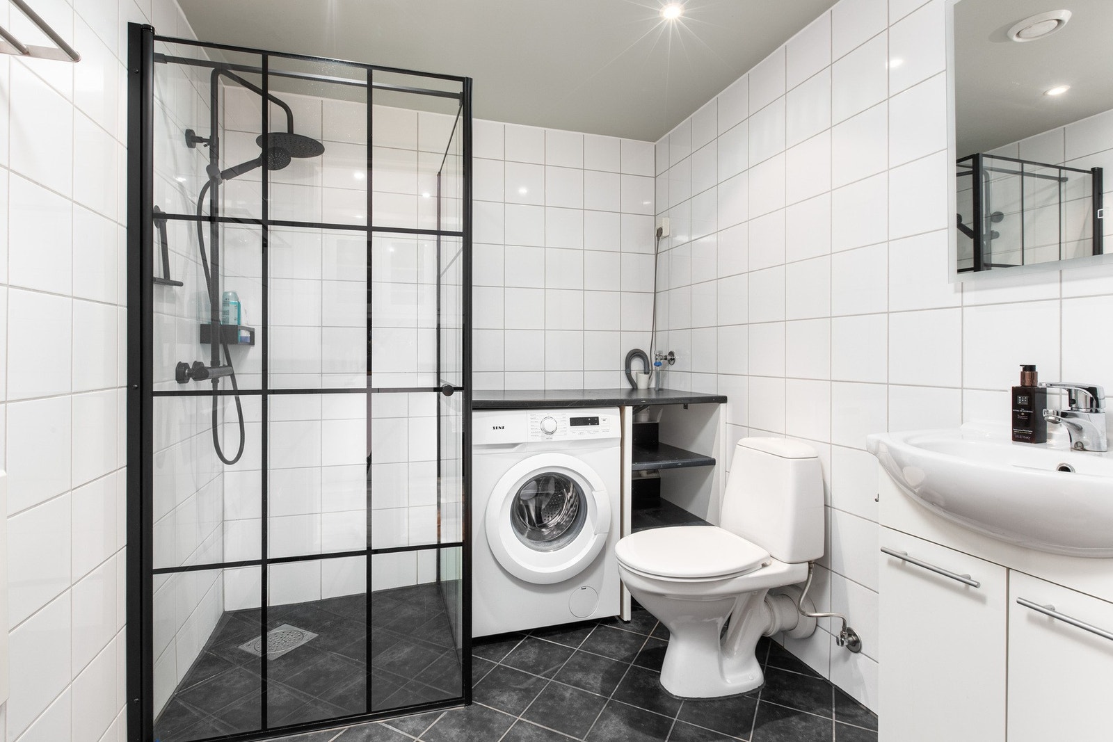 Badet har innredning med nedfelt servant, gulvfestet toalett, oppgradert dusjhjørne og opplegg for vaskemaskin (Foto: Jon Martin Austad) Galleribilde