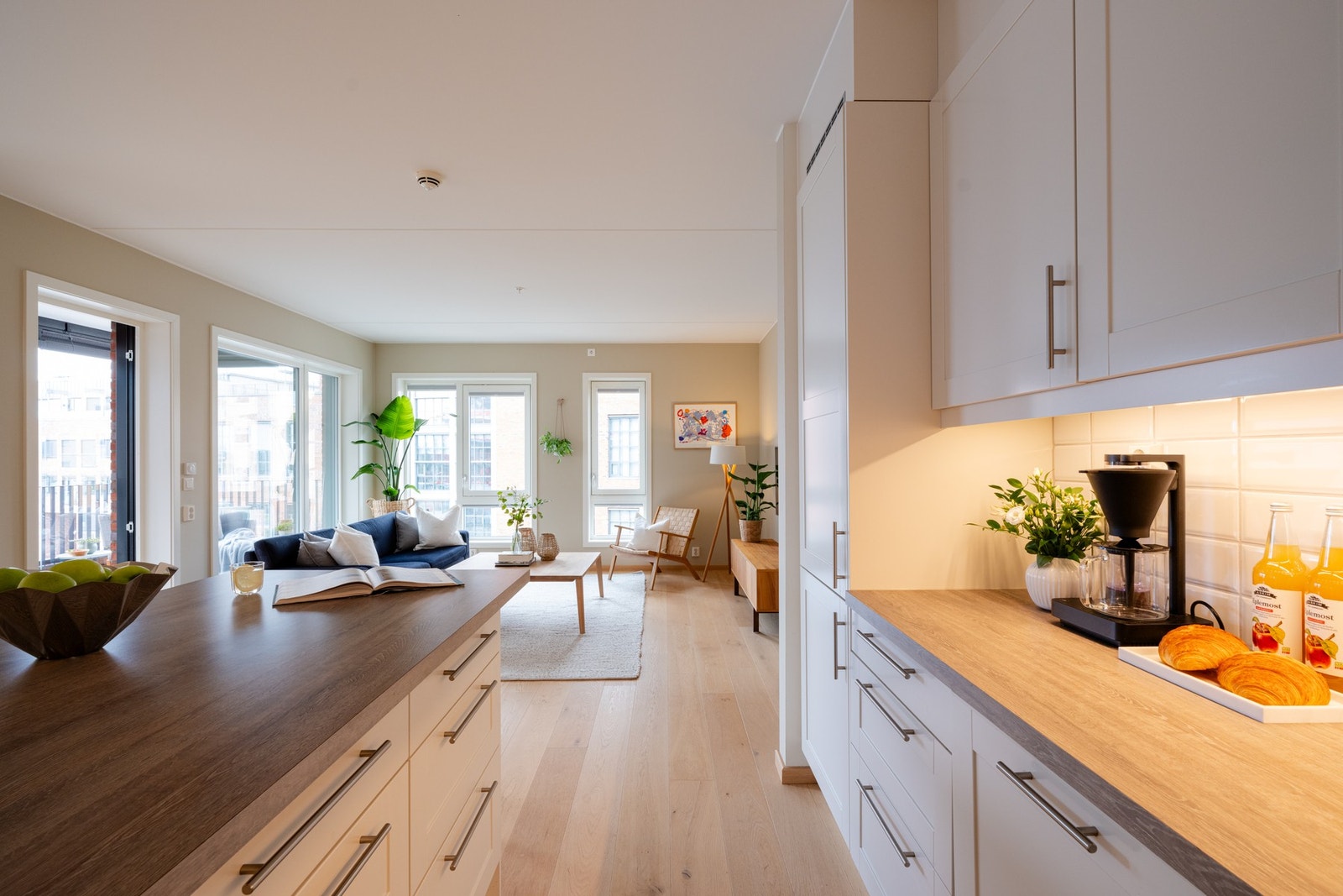 Lys kjøkkeninnredning med profilerte fronter, laminat benkeplate og nedfelt oppvaskkum med ett-greps armatur. Galleribilde