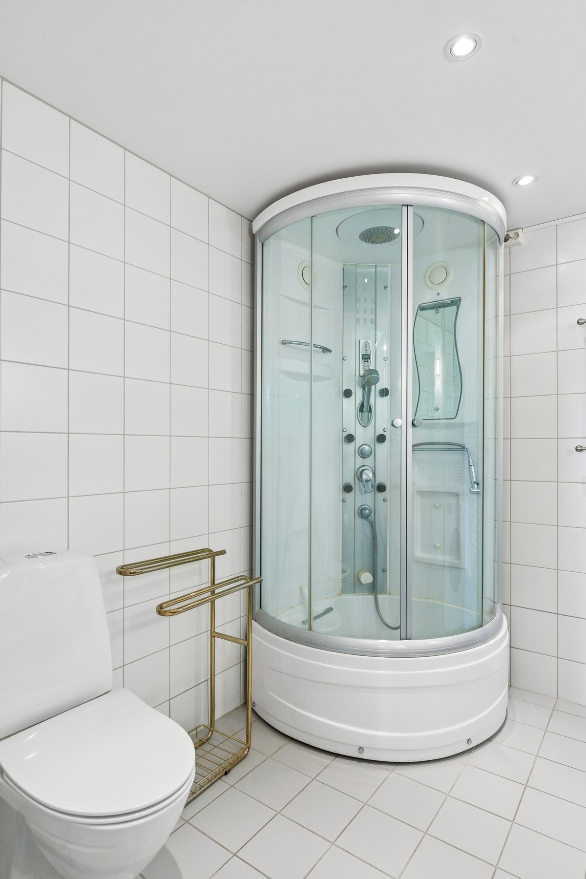 Bad med dusjkabinett, toalett, dobbel servant og opplegg for vaskemaskin. Galleribilde