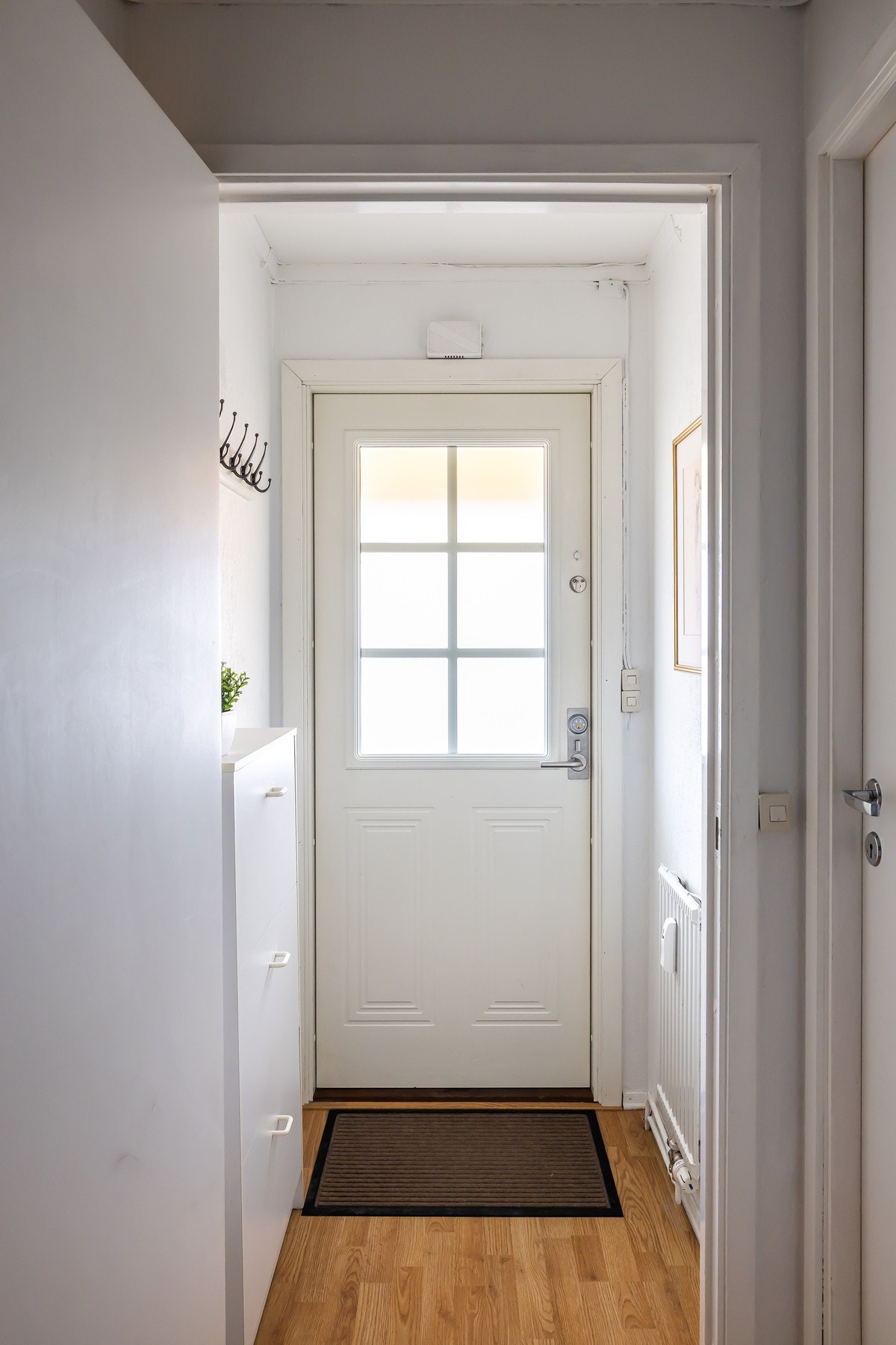 Velkommen inn i en praktisk entré med plass til oppheng av yttertøy og sko Galleribilde