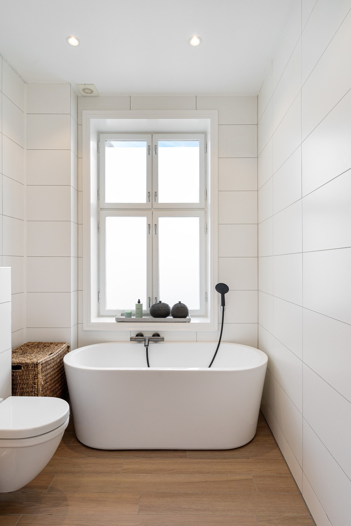 Badet er innredet med servantskap med nedfelt servant, speil med belysning, vegghengt toalett med innebygd sisterne og frittstående badekar. Galleribilde