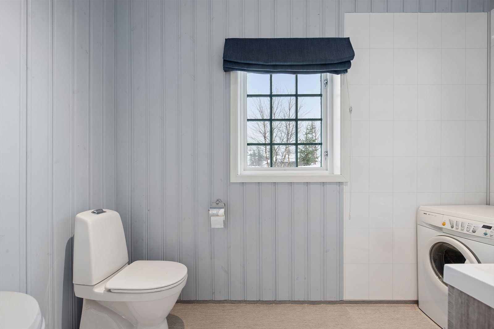 Badet i tilleggsdelen har trepanel og baderomsplater på veggene, samt vinylbelegg på gulvet med elektriske varmekabler som gir behagelig temperatur Galleribilde