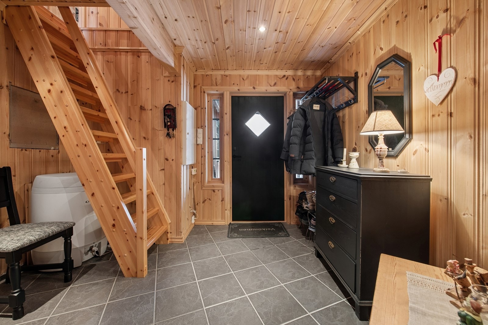 Entréen ønsker deg velkommen inn i hytta og fremstår som lys og praktisk. Gulvet er belagt med fliser med elektriske varmekabler, noe som gir en komfortabel temperatur på kalde dager. Her er det gode muligheter for oppheng av yttertøy og plass til sko Galleribilde