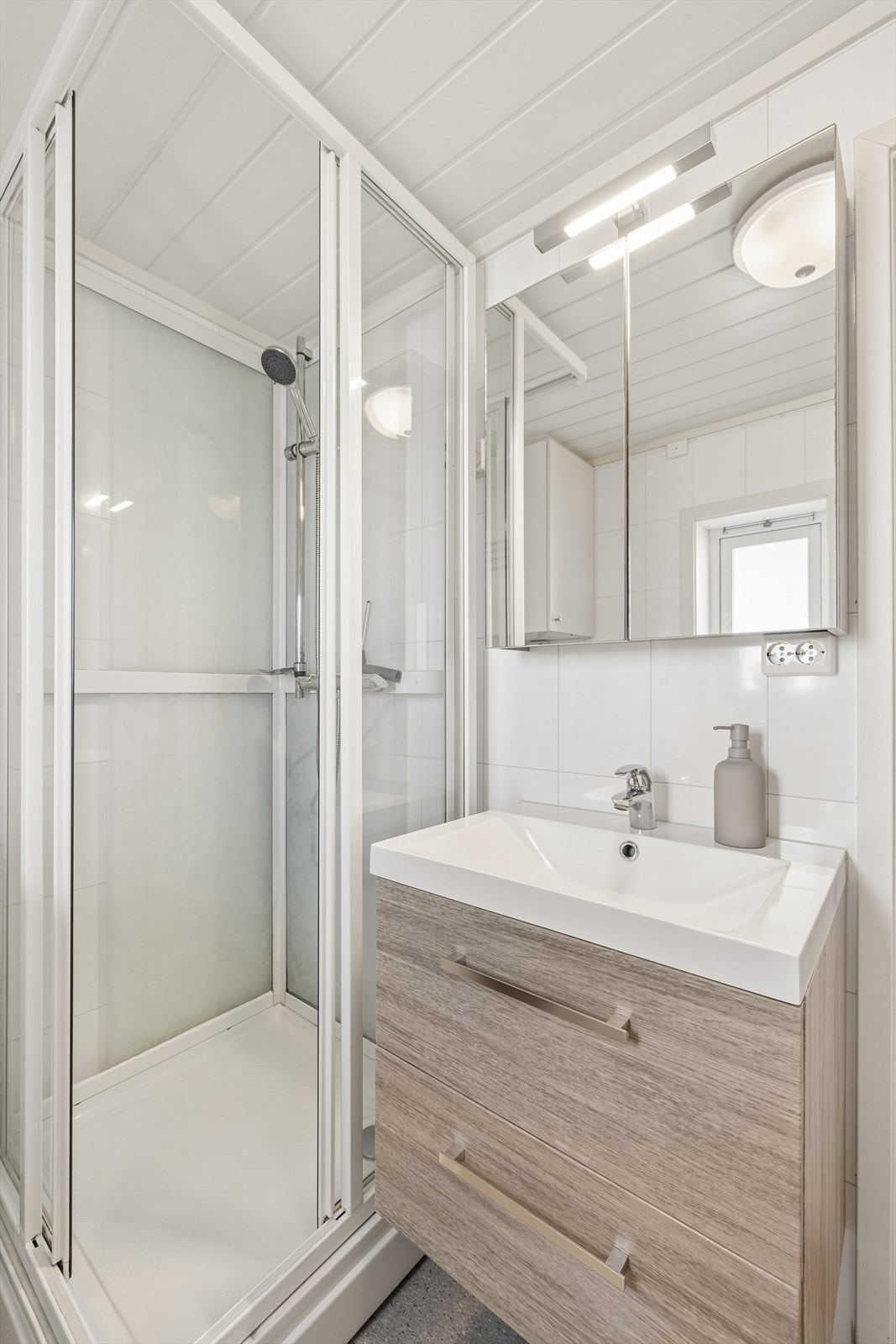 Det andre badet i første etasje har belegg på gulv, gulvvarme og dusjkabinett. Galleribilde