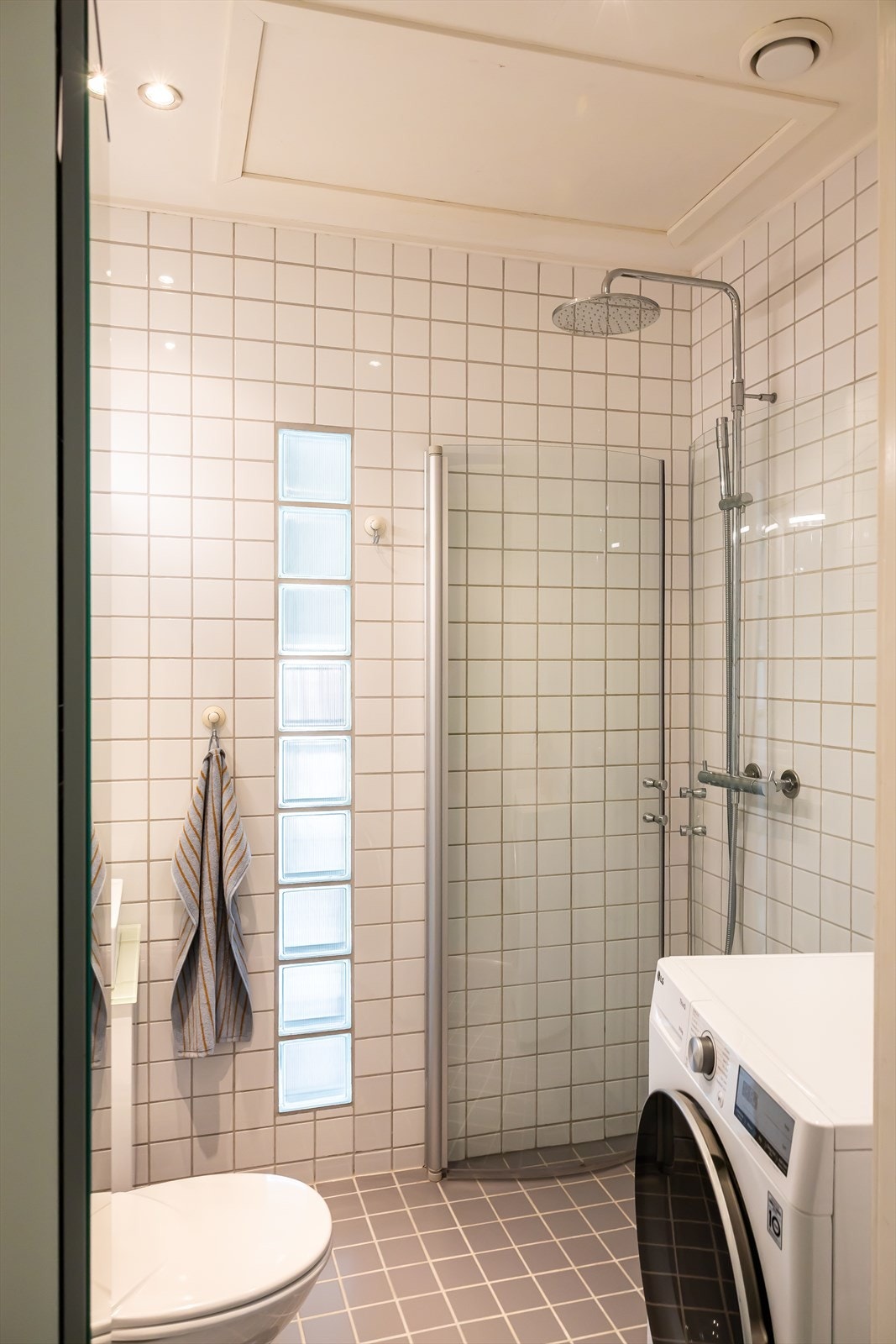 Dusjhjørne med innfellbare dører og opplegg for vaskemaskin. Galleribilde