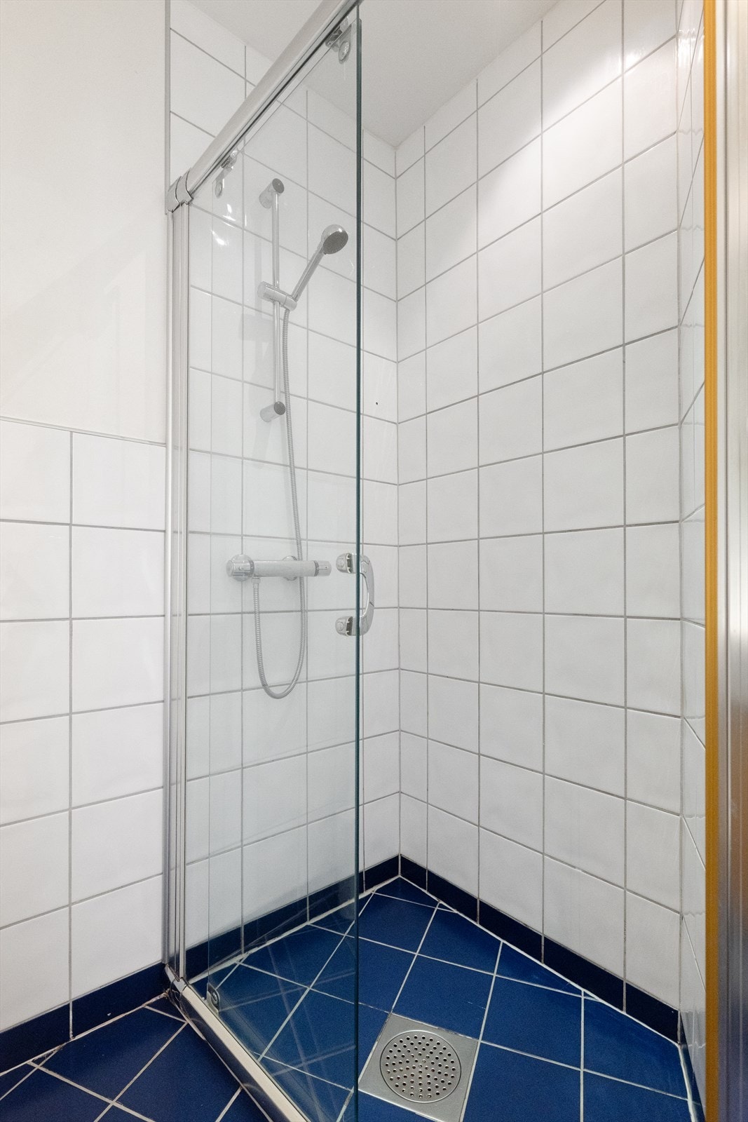 Badet er innredet med veggmontert WC, dusjplass med dusjvegg og servant med ettgreps blandebatteri i innredning. Galleribilde