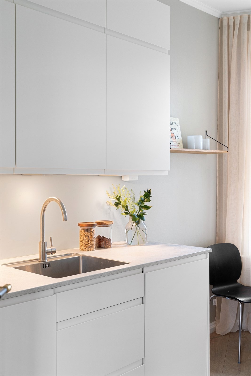 Det er kullfiltervifte over integrert koketopp og ovn, samt integrert kjøl og frys. Videre har kjøkkenet kum med ettgreps blandebatteri, belysning under overskap, opplegg for vaskemaskin og integrert oppvaskmaskin. Galleribilde