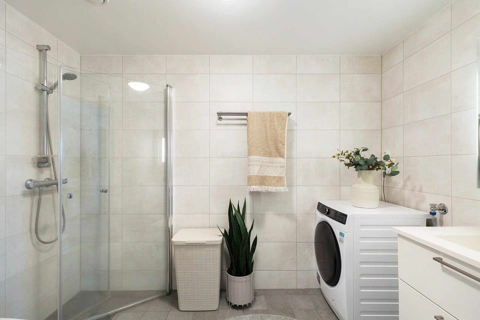 Badet er utstyrt med veggmontert wc, innfellbare dusjdører, opplegg for vaskemaskin, servant og servantskap. Galleribilde