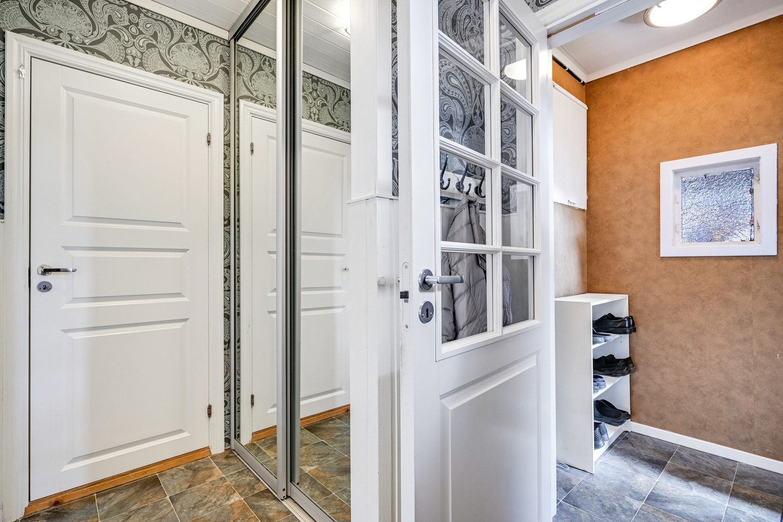 Vindfang med plass for skoskap mm og videre til entree med skyvedørsgarderobe Galleribilde