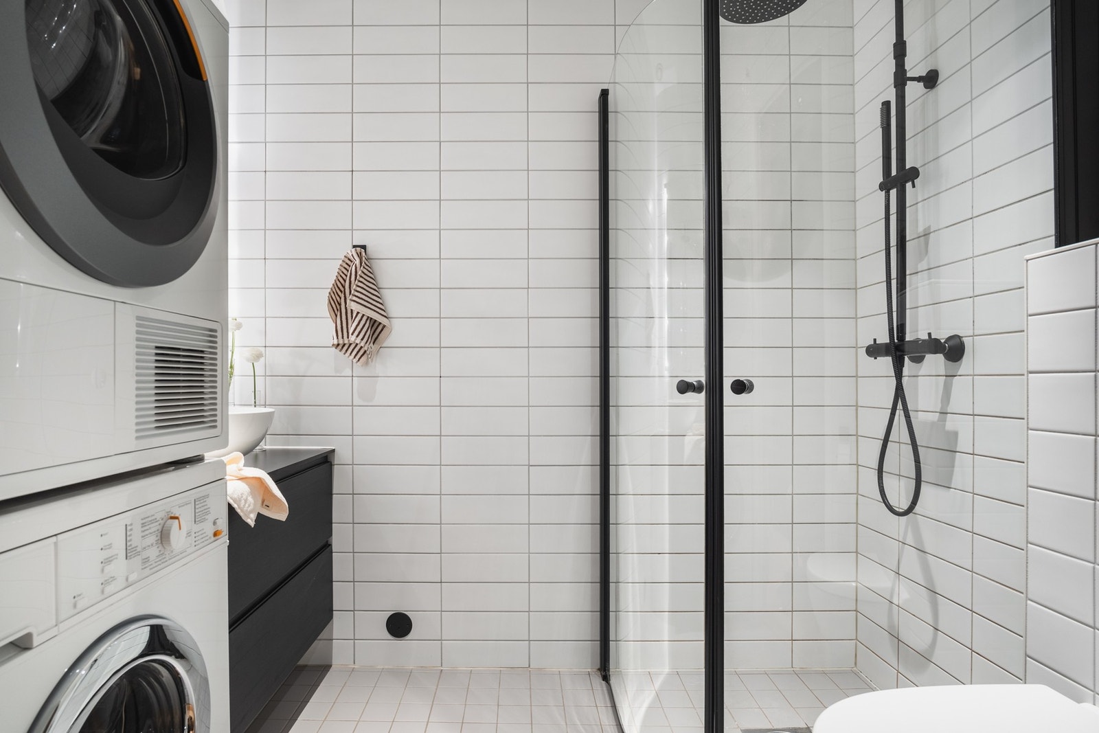 Badet er flislagt og har opplegg for vaskesøyle. De innfellbare dusjveggene i glass gir god plassutnyttelse. Galleribilde