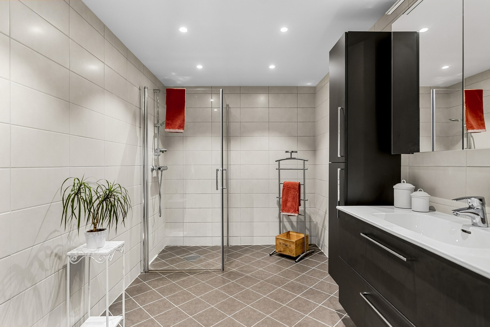 Badet er utstyrt med dusjhjørne med dører, vegghengt toalett og et moderne rør-i-rør-system. Galleribilde