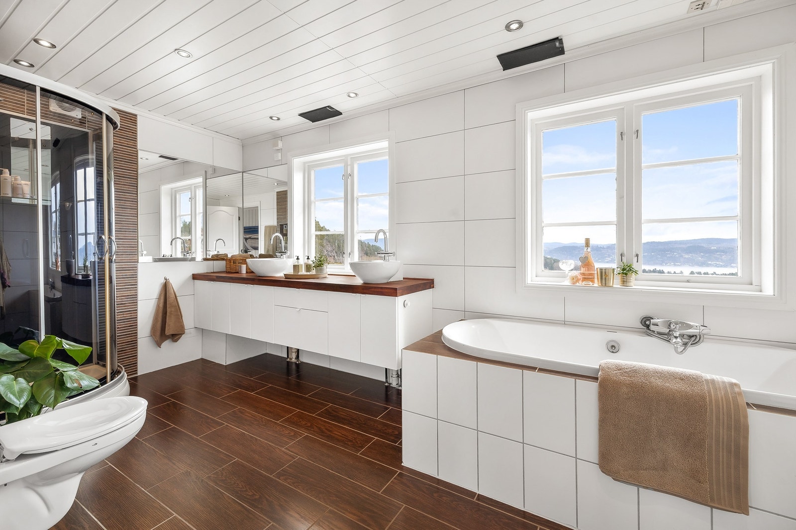 Det flislagte badet har varme i gulvet og er utstyrt med både innebygget badekar og dusjkabinett. Innredningen er fra KVIK. Galleribilde