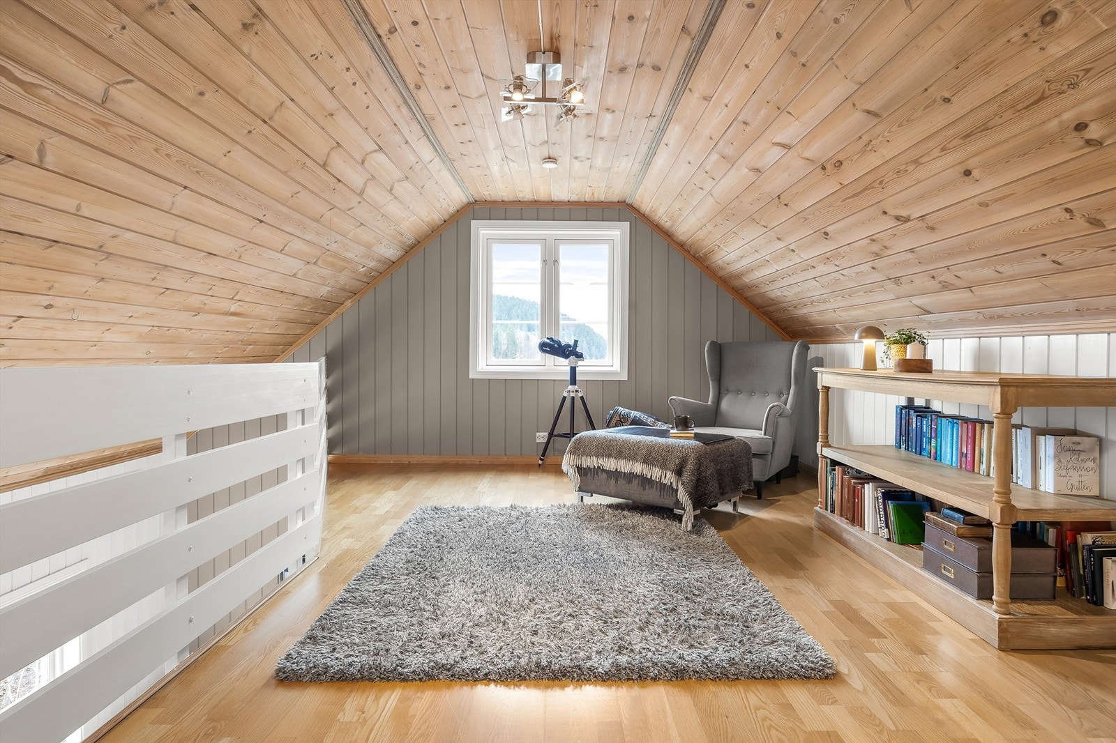 Innredet stue på loftet er lunt og tilbaketrukket med parkett på gulvet og ubehandlet panel i taket. (Det foreligger ikke tegninger av loftet). Galleribilde