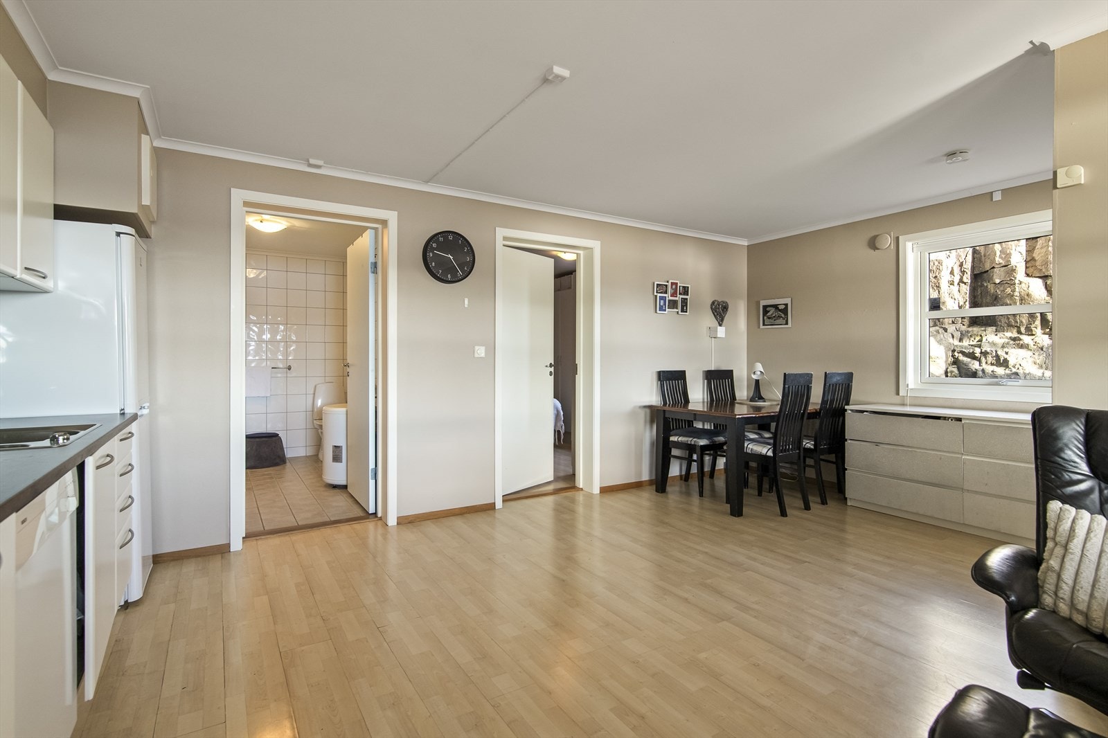 Stuen og kjøkkenet ligger i åpen løsning, med laminatgulv og er malt i fargen Sand på vegger. Kjøkkeninnredningen har lyse, glatte fronter, oppvaskkum og benkeplate av laminat. Galleribilde