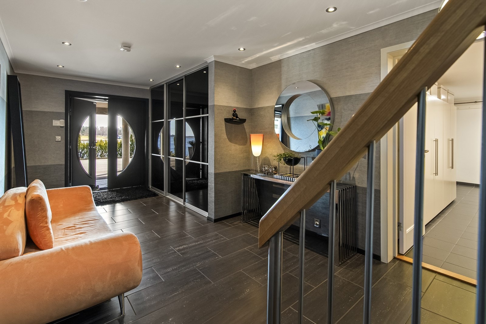 Inne møtes man av en flott hall med downlights, store, mørke gulvfliser og veggtapet i ulike grånyanser. Yttertøyet ryddes enkelt bort i en stor, plassbygd skyvedørsgarderobe. Galleribilde