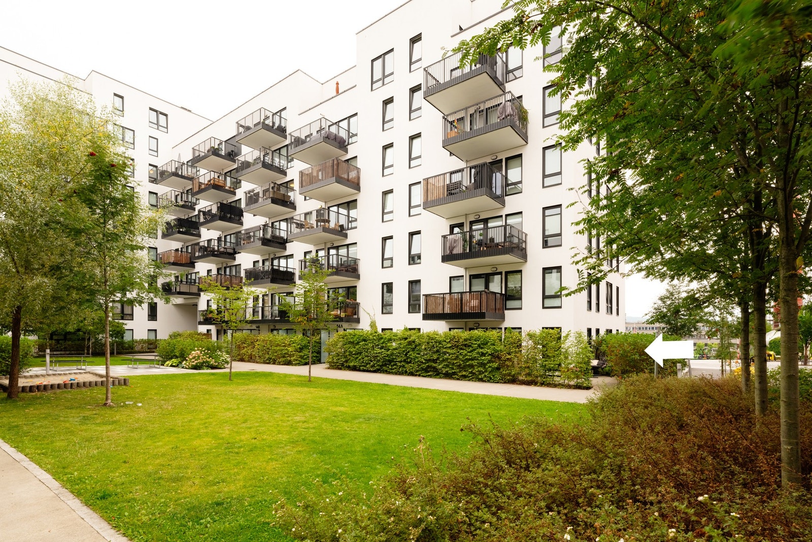 Krydderhagen er kjent for sine pene, grønne områder mellom bebyggelsen. Pil peker mot leiligheten vi nå har for salg. Galleribilde