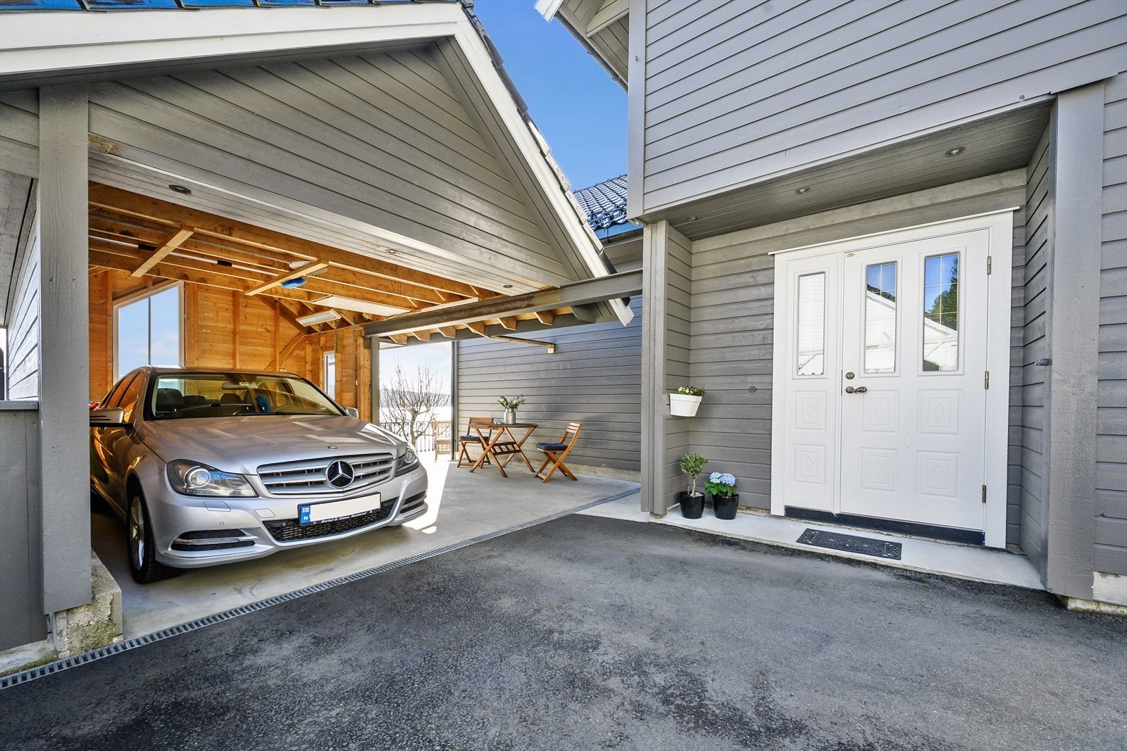 Praktisk carport med enkel parkering ved hovedinngang Galleribilde