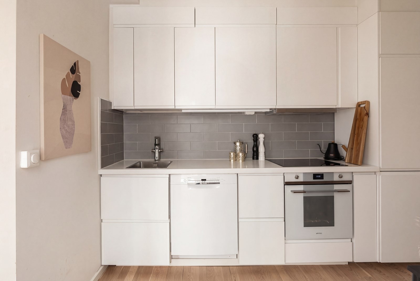 Kjøkkenet disponerer integrert platetopp, stekeovn, kjæl/fryseskap, kullfilterventilator, samt oppvaskmaskin. Bildet er AI-redigert. Galleribilde