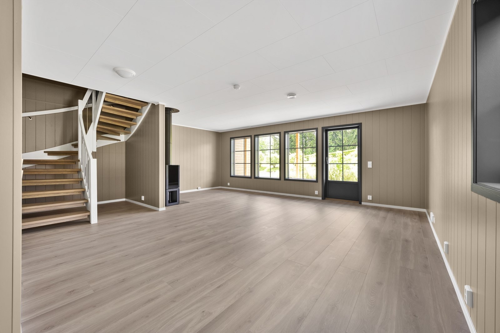 Stuen har god plass til både sofagruppe og spisebord. Den hvite vindeltrappen er en stilren detalj. Galleribilde