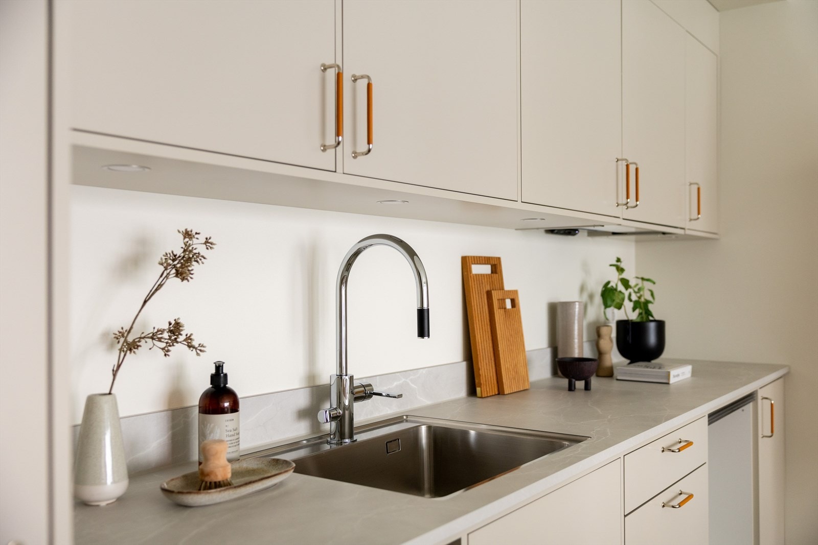 Innredningen er fra HTH med glatte, moderne fronter, backsplash på vegg og laminert benkeplate Galleribilde