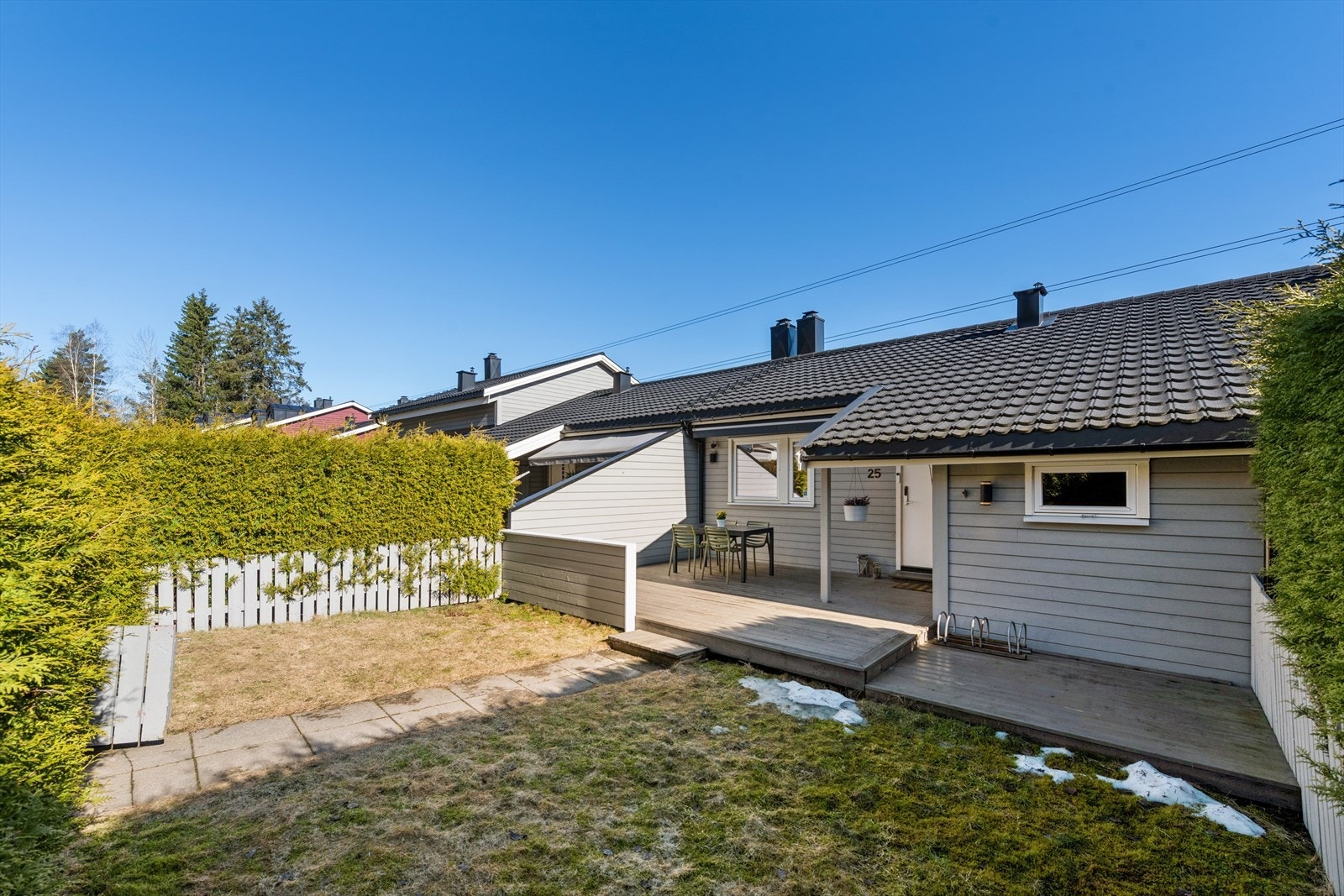 Vestvendt fasade med hage, terrasse, utebod og overbygd inngangsparti. Galleribilde