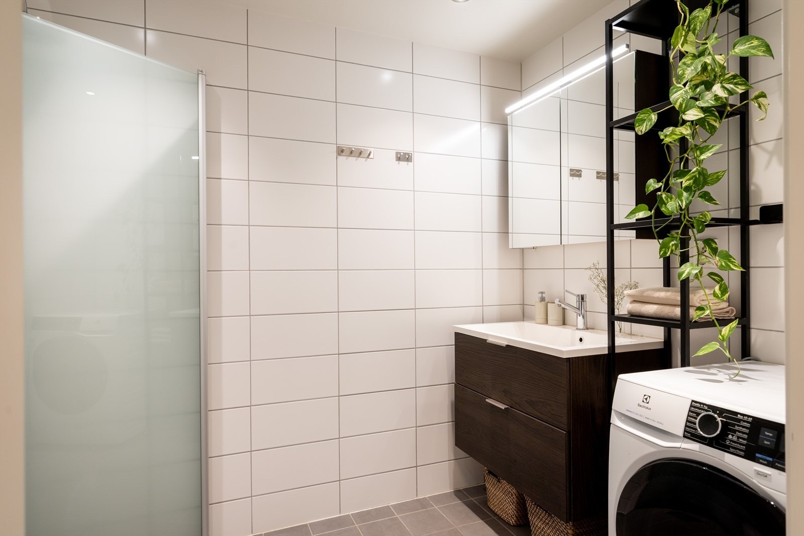Badet er stilrent med lyse fliser på vegger og gulv. Galleribilde