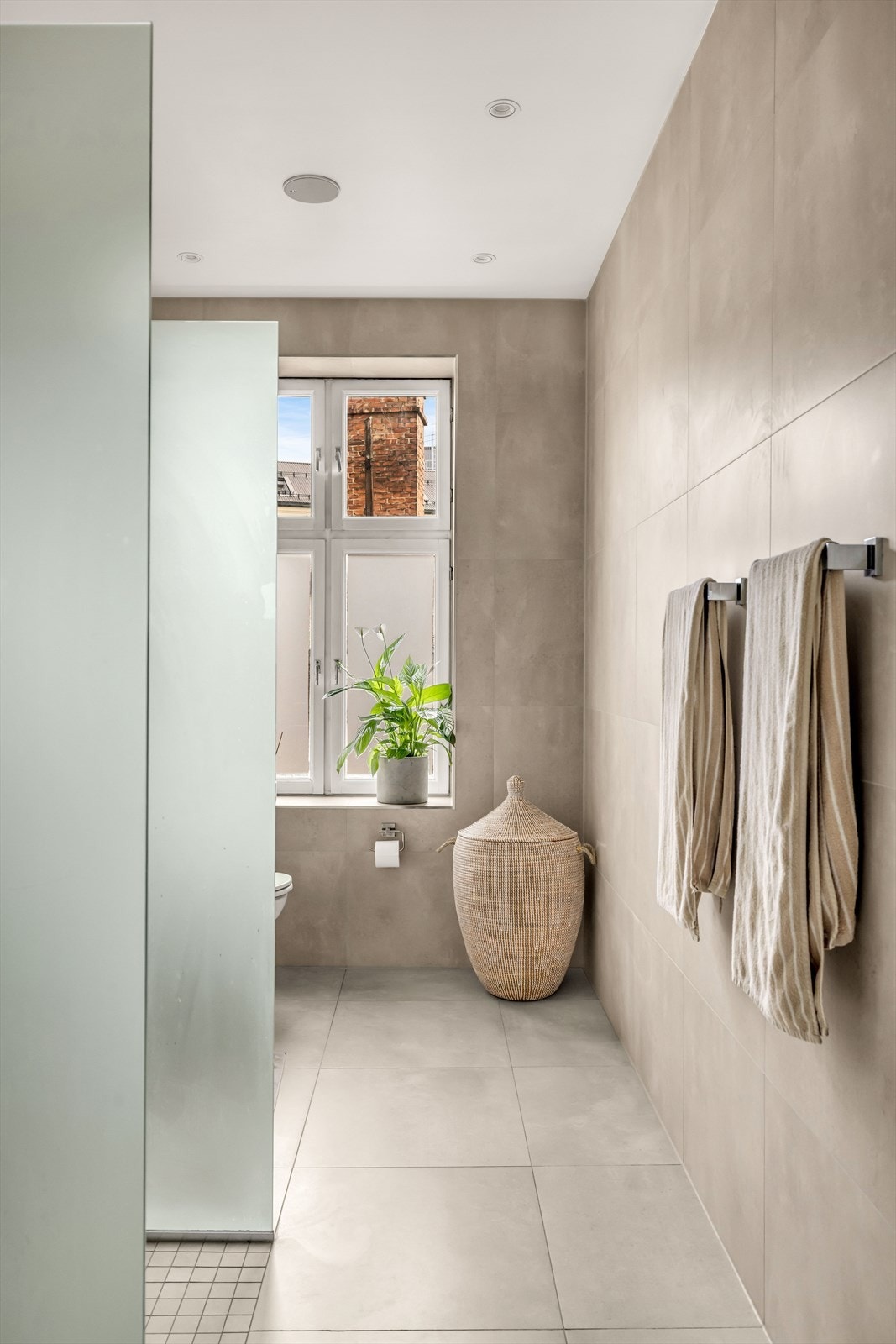 Badet er innredet med servantskap med ettgreps blandebatteri, vegghengt toalett med innebygget sisterne, speil med lys, avskjermet dusjhjørne med glass, blandebatteri og dusjgarnityr. Galleribilde