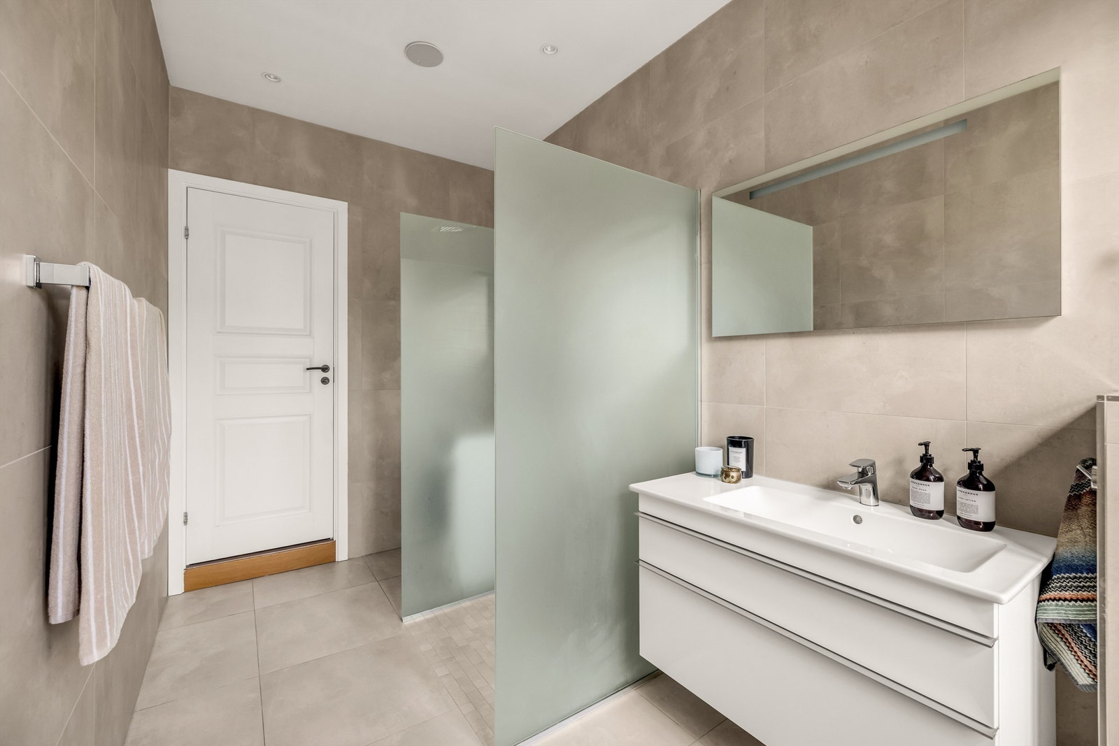 Romslig dusj med dusjvegger i herdet glass. Badet har integrerte høytalere i taket. Galleribilde