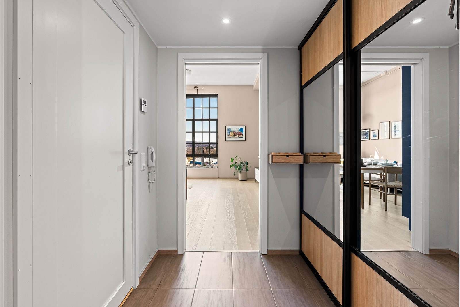 Entré med fliser og gulvvarme, downlights i himling og spesialbestilt skyvedørsgarderobe Galleribilde