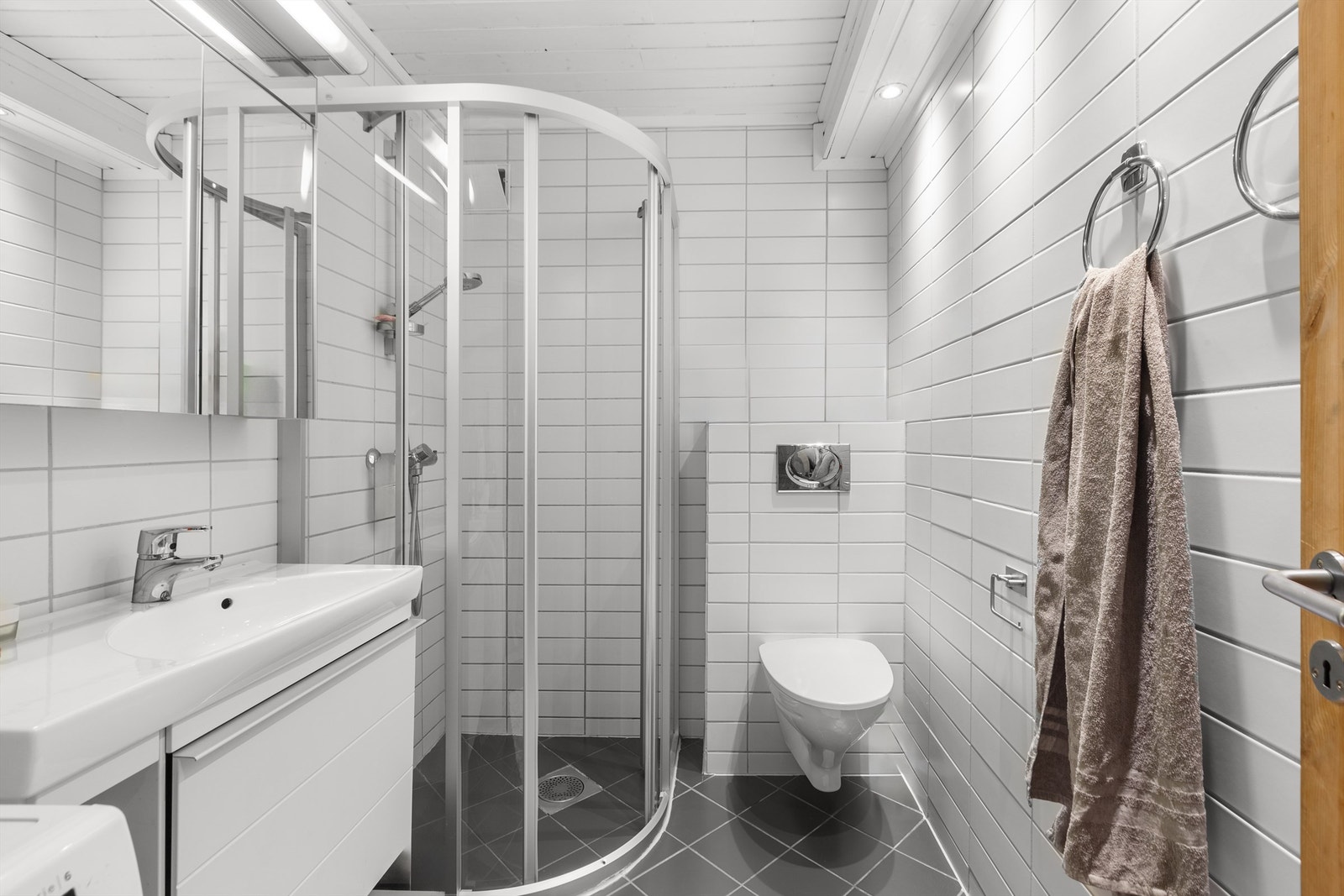 Badet i underetasjen er fra ca. 2007, flislagt og utstyrt med dusjhjørne, vegghengt toalett og varmekabler i gulvet. Galleribilde