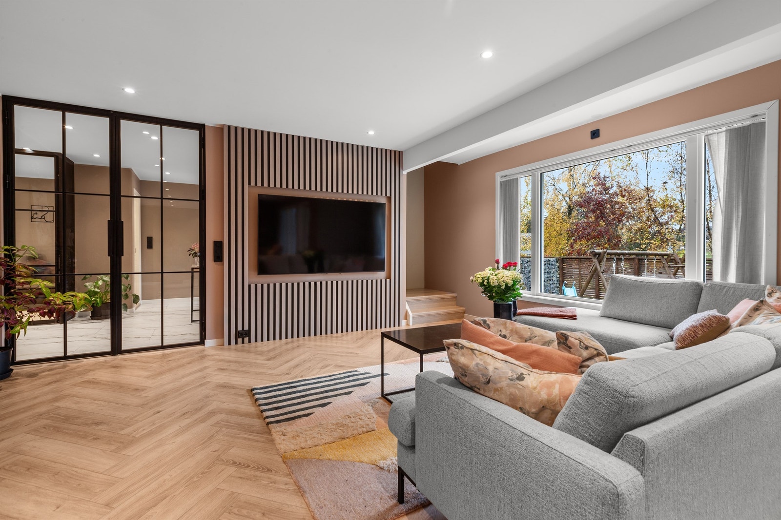 En moderne spilevegg med plass til TV er et av rommets stilfulle elementer. Galleribilde