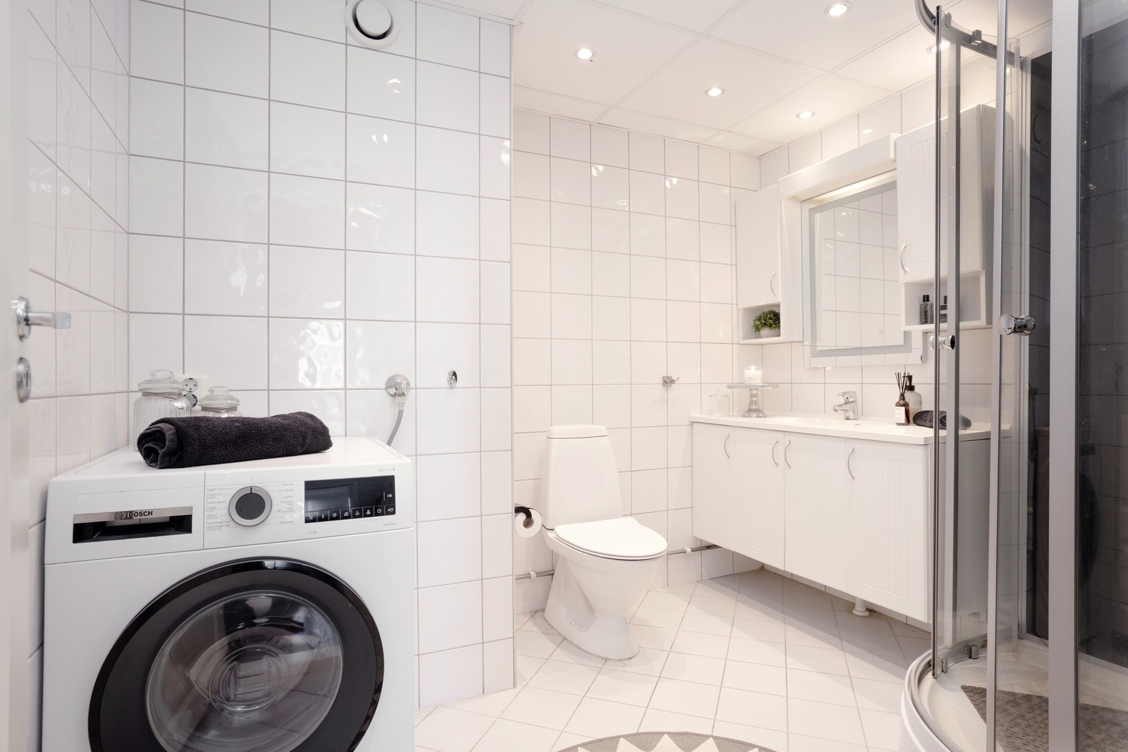 Fin størrelse på badet, her er det servant med oppbevaring, dusjkabinett og opplegg for vaskemaskin. Galleribilde